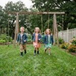 Trois enfants jouent dans un jardin verdoyant