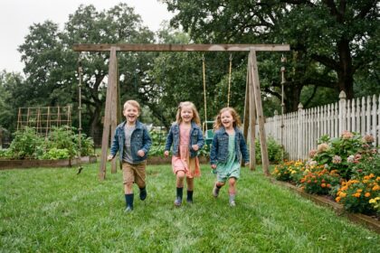 Trois enfants jouent dans un jardin verdoyant