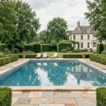 Vue panoramique d'une belle piscine extérieure dans un jardin des Yvelines avec terrasse et végétation luxuriante