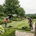 Équipe de paysagistes professionnels aménageant un grand jardin résidentiel dans le Val-d'Oise